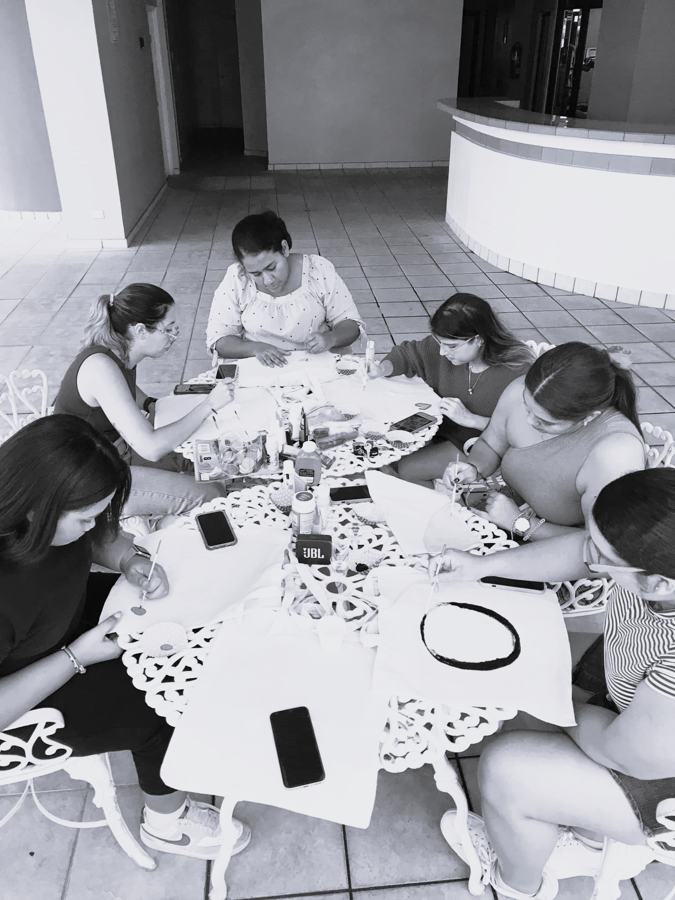 Mujeres creando en una mesa de talleres