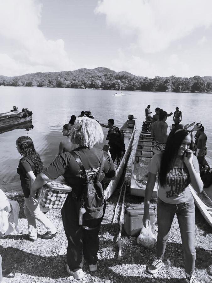 Personas junto a botes en la orilla de un río