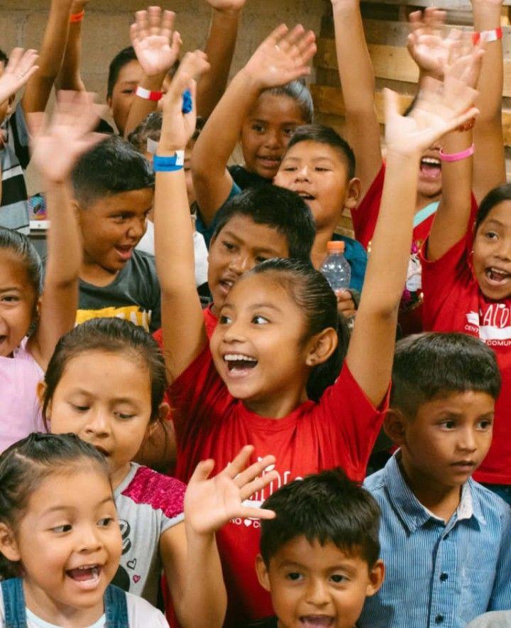 Niños y niñas con las manos levantadas