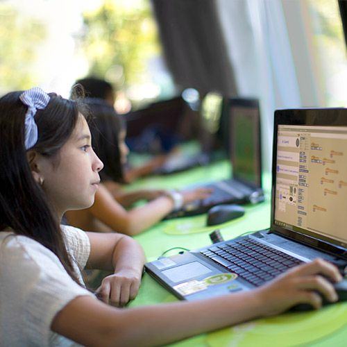 Niña usando una laptop en un taller de tecnología